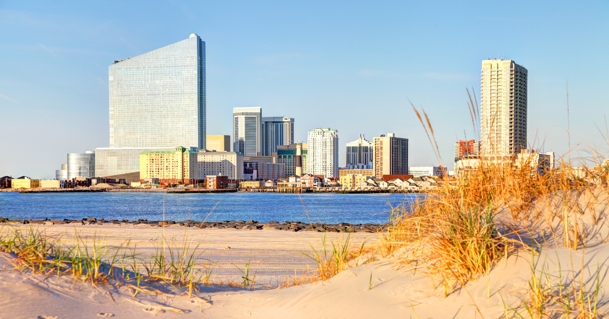 View of the Atlantic City skyline from the sandy dunes of Brigantine, NJ, showcasing the perfect blend of peaceful beach town charm and nearby excitement—ideal for highlighting Brigantine vacation rentals on ShoreSummerRentals.com.