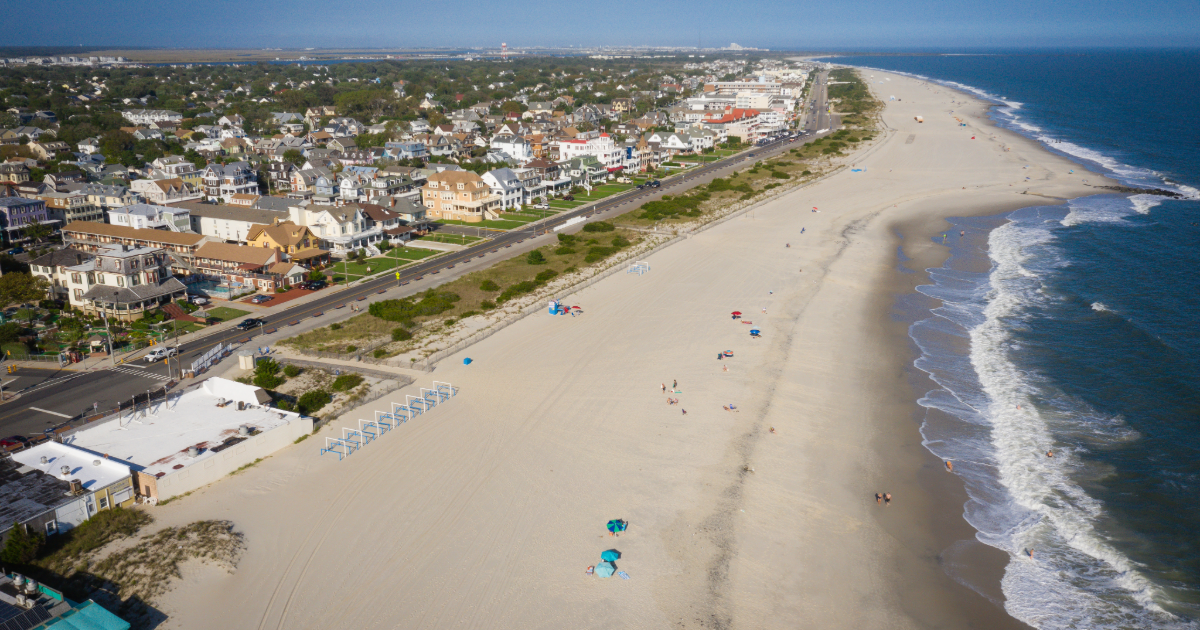Scenic view of Cape May with a beach, lighthouse, and boardwalk, ideal for planning your Cape May vacation and exploring top Cape May rentals, beach rentals, and summer rental options.